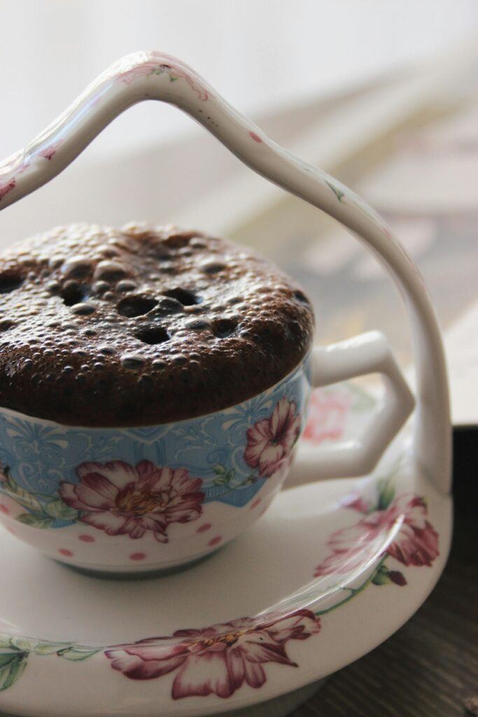Close-up of a chocolate mug cake in a floral teacup, perfect for dessert lovers.